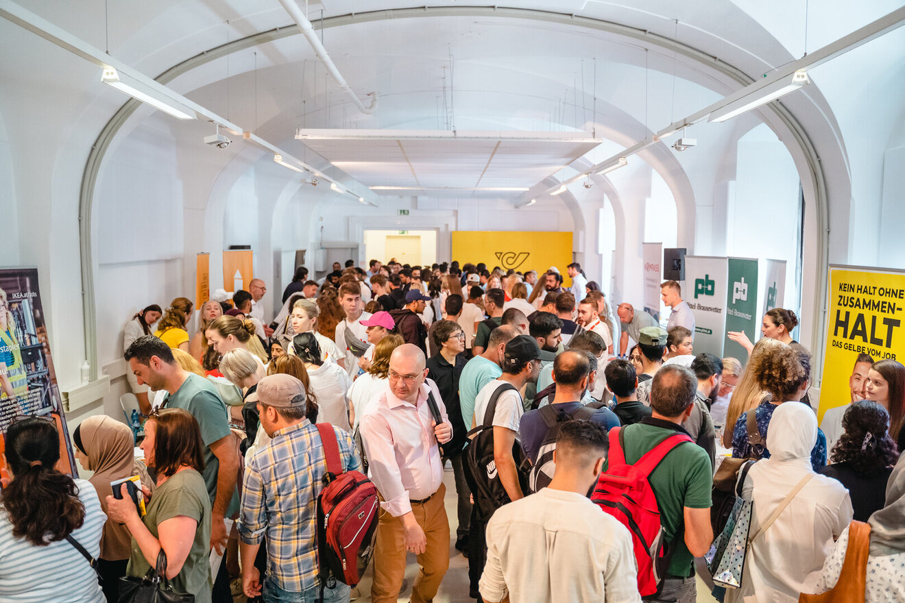 Ein großer Menschenauflauf in einem Innenraum, der ein Lebendigkeits- und Vernetzungs-Event zeigt.